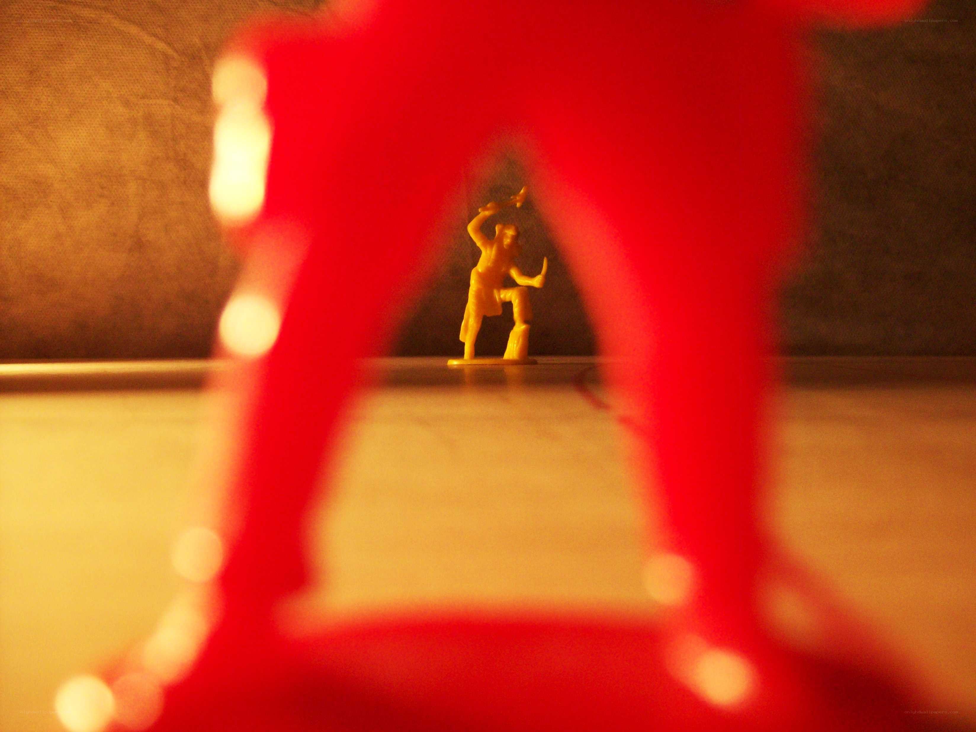 Yellow toy figure between red legs