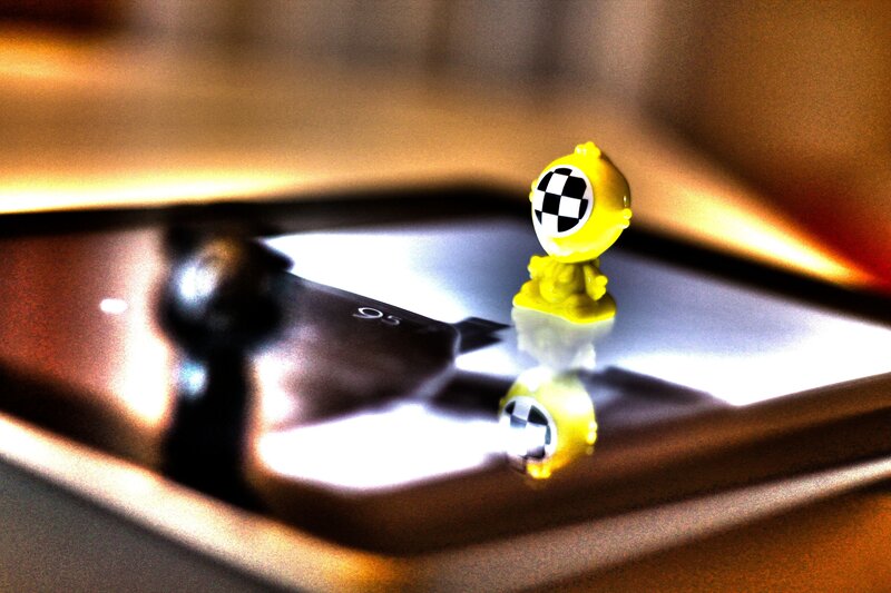 Yellow toy on reflective surface