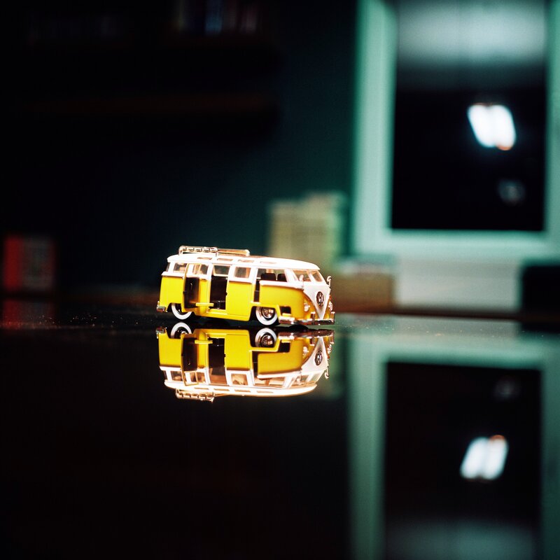 Yellow toy van on reflective surface