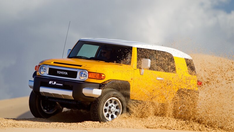 Yellow Toyota FJ Cruiser on sand
