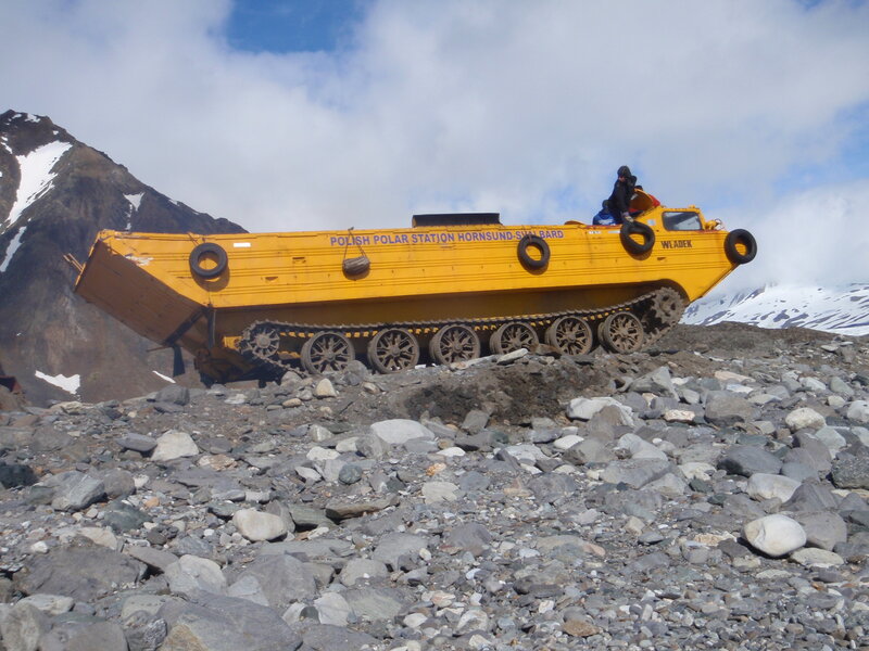 Yellow tracked vehicle on rocky terrain