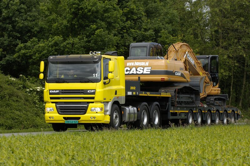 Yellow truck carrying excavator
