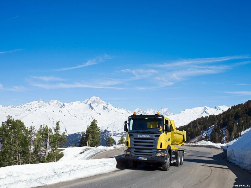 Yellow truck on snowy mountain road