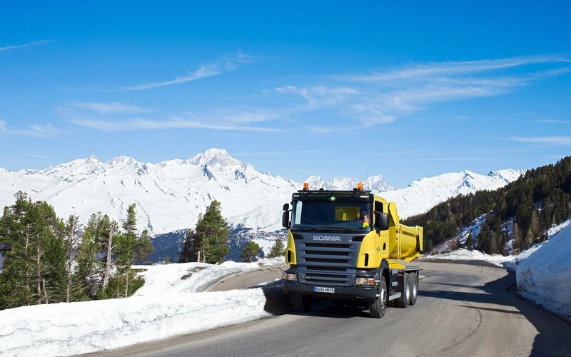 Yellow truck on snowy mountain road