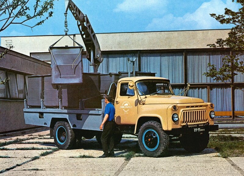 Yellow truck with crane lifting cargo