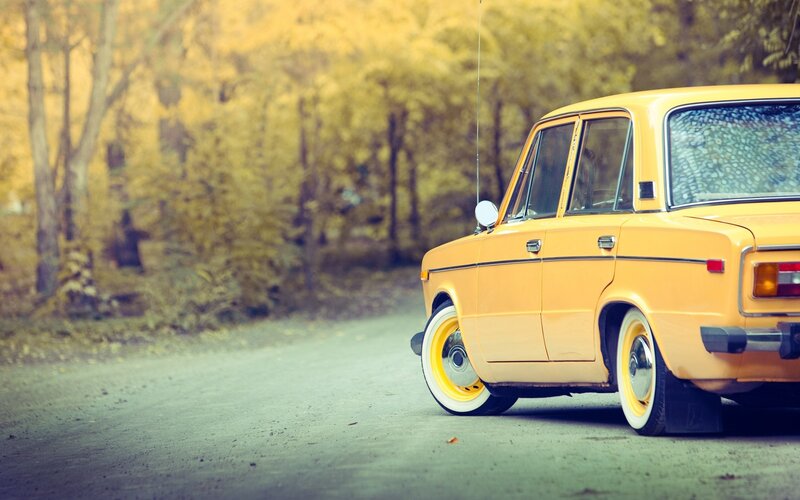Yellow vintage car on a forest road