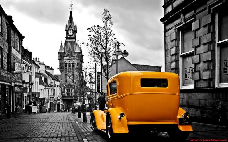 Yellow vintage car on cobblestone street