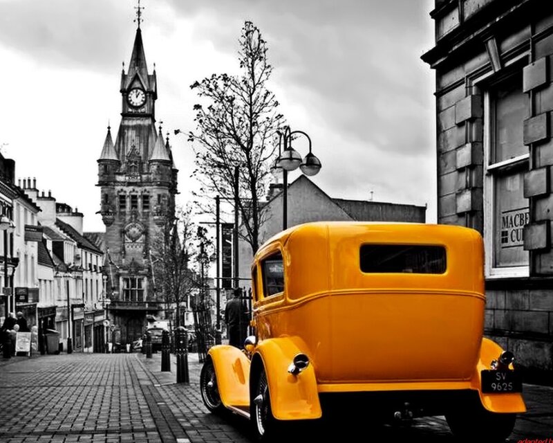 Yellow vintage car on cobblestone street