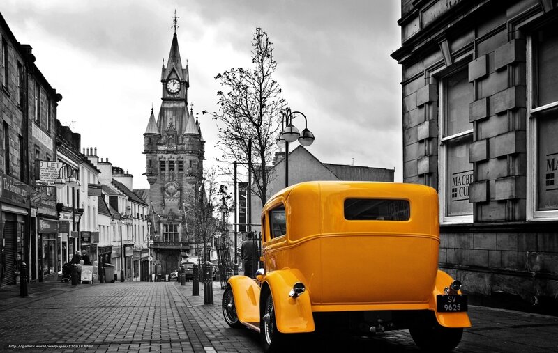 Yellow vintage car on cobblestone street