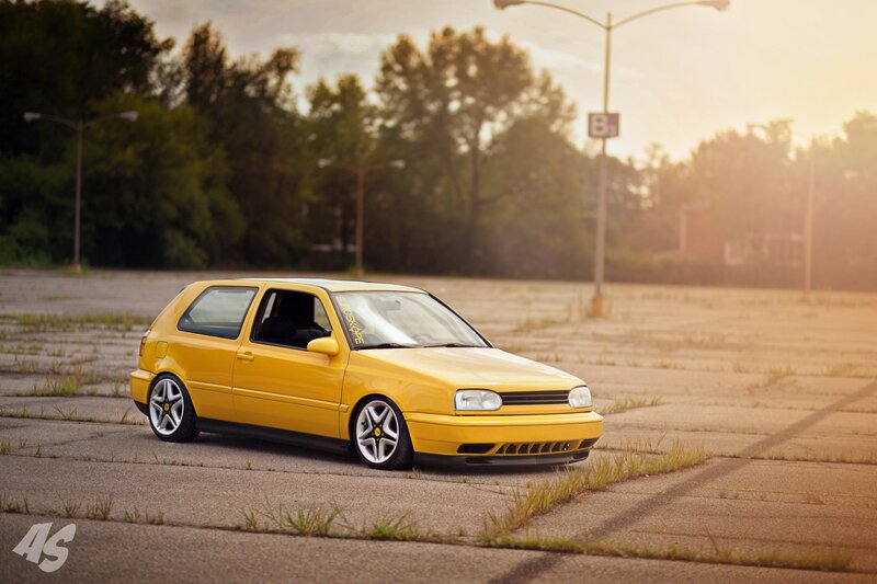 Yellow Volkswagen Golf in parking lot