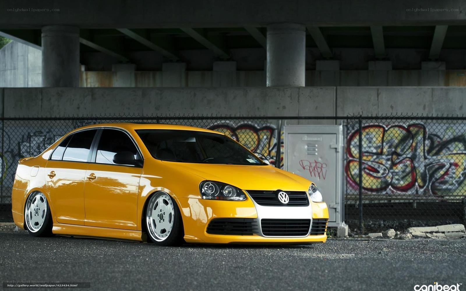 yellow volkswagen jetta under bridge