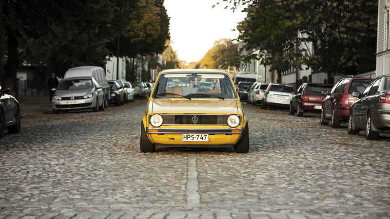 Yellow Volkswagen on cobblestone street