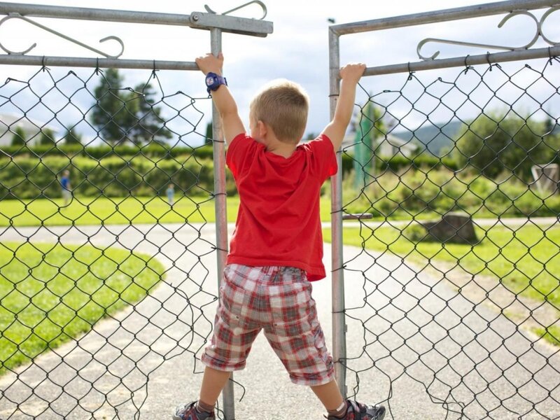 Young Boy Climbing Fence