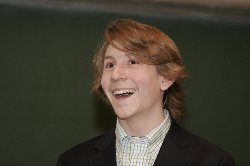 young boy laughing in suit