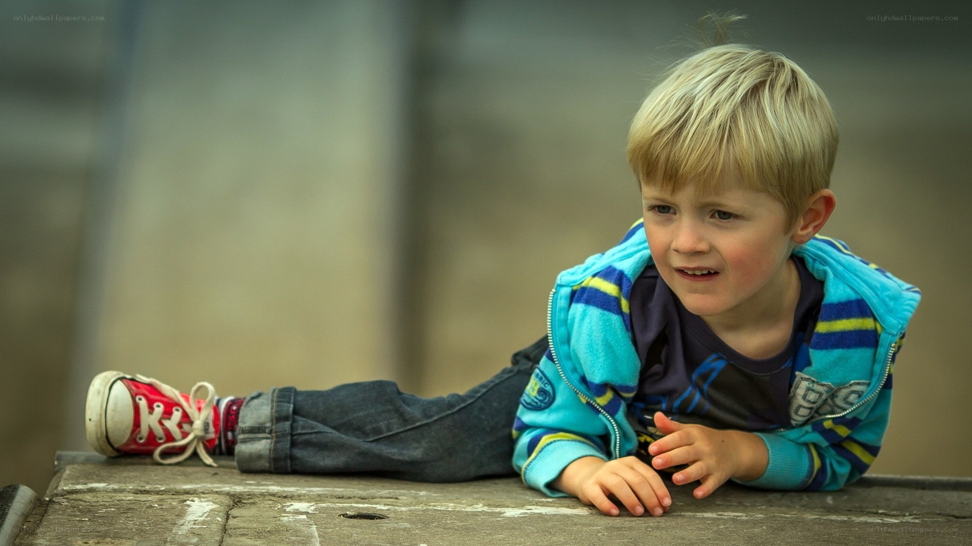 young boy lying on a bench