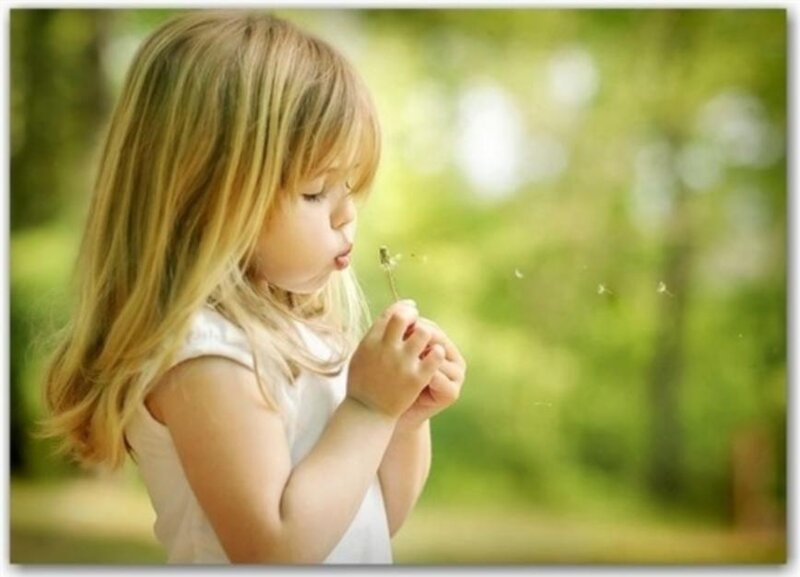 Young Girl Blowing Dandelion