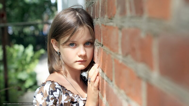 Young Girl by Brick Wall
