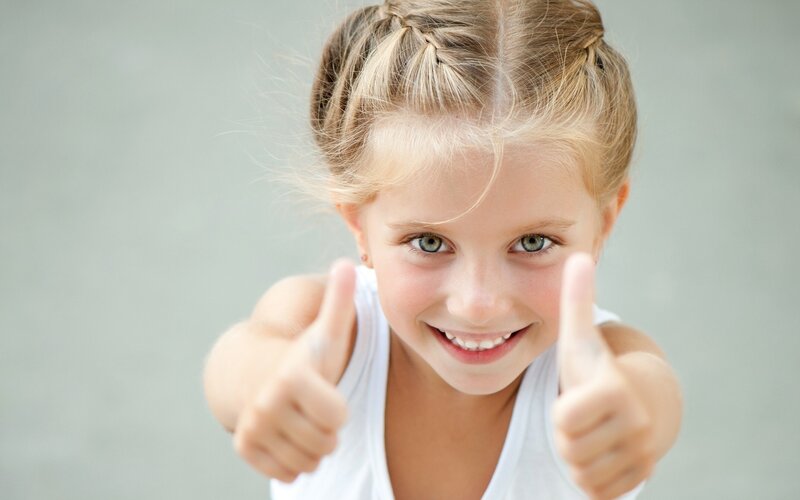 Young Girl Giving Thumbs Up — White