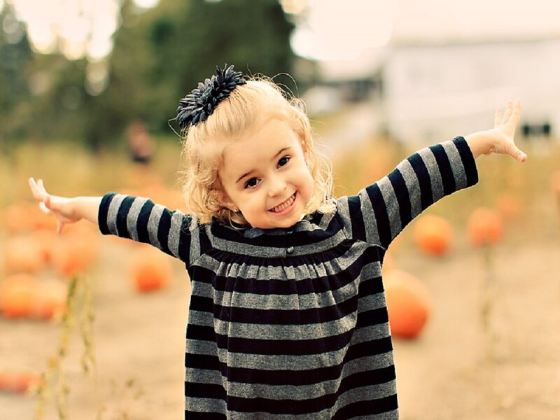 Young Girl in Pumpkin Patch — Orange