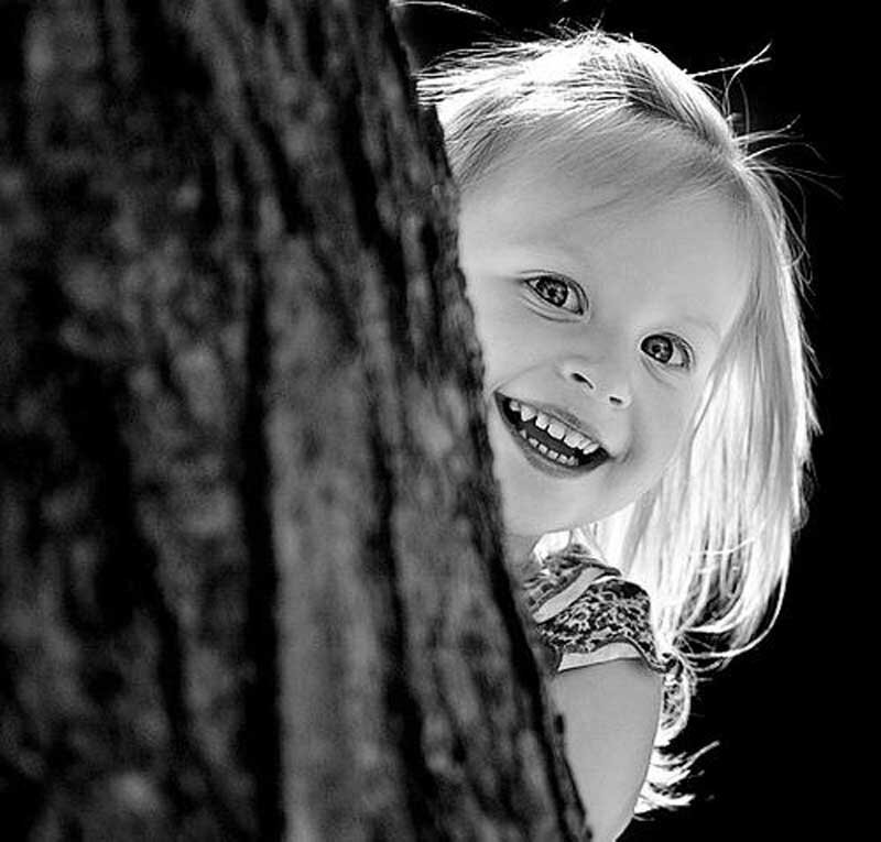 Young Girl Peeking from Tree