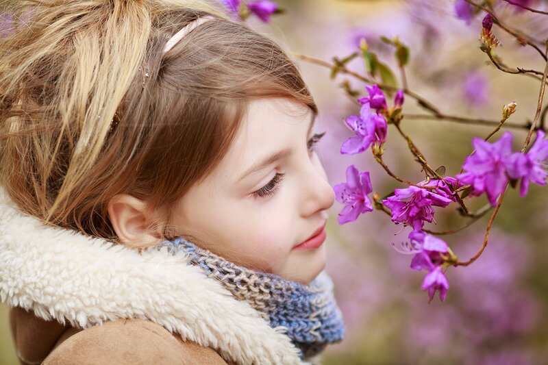 Young Girl Smelling Flowers — Purple