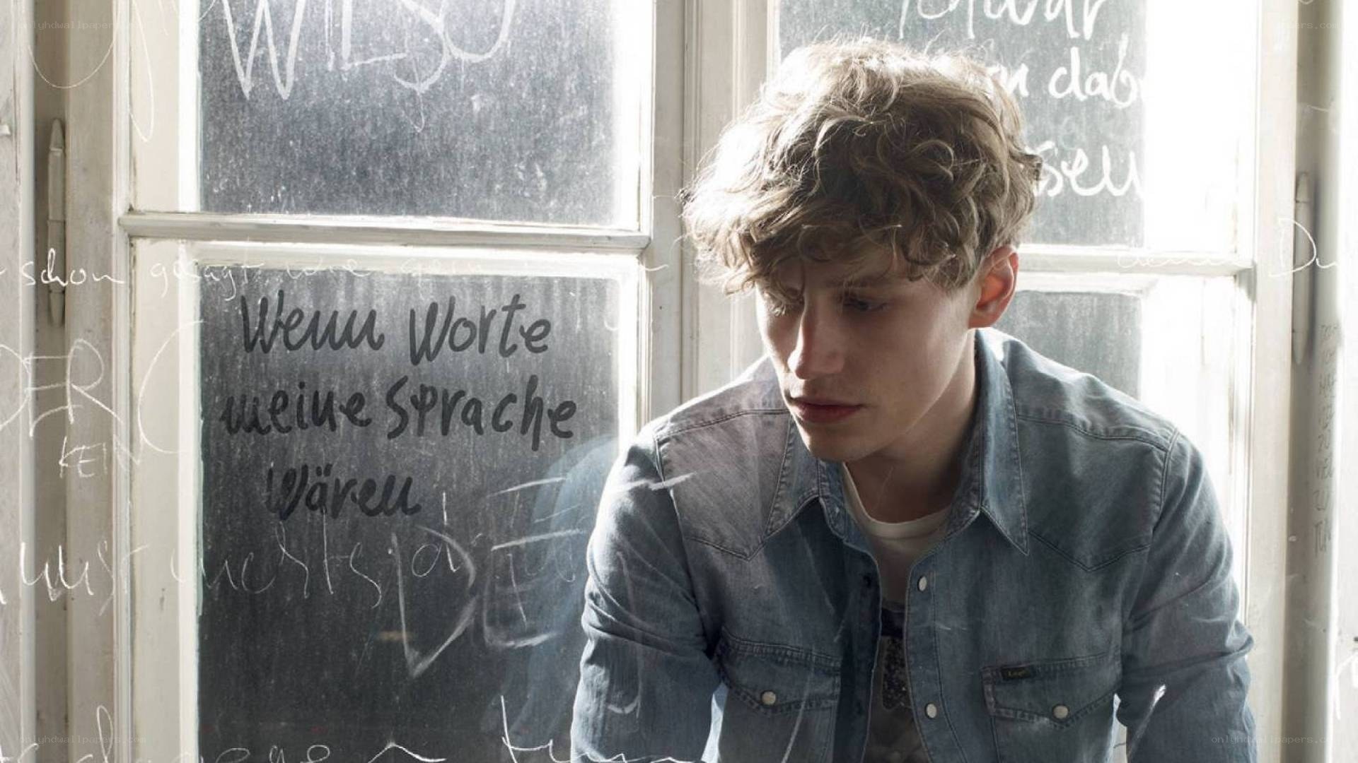 Young man by a chalkboard window