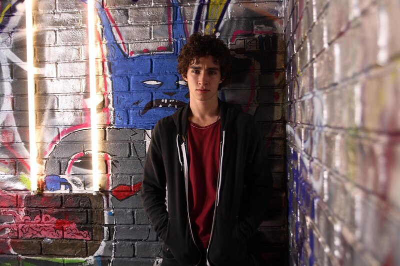 Young man in graffiti alley