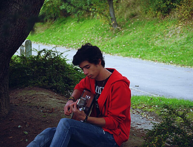 Young man playing guitar outdoors