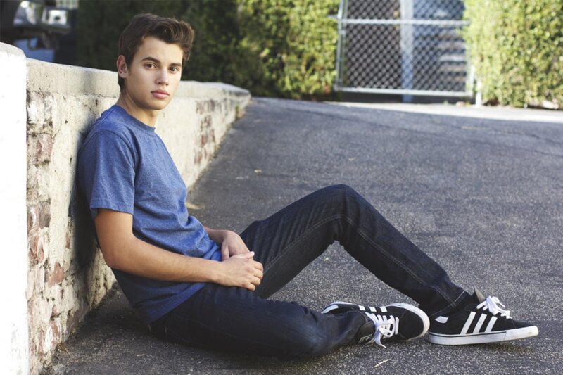 young man sitting on pavement