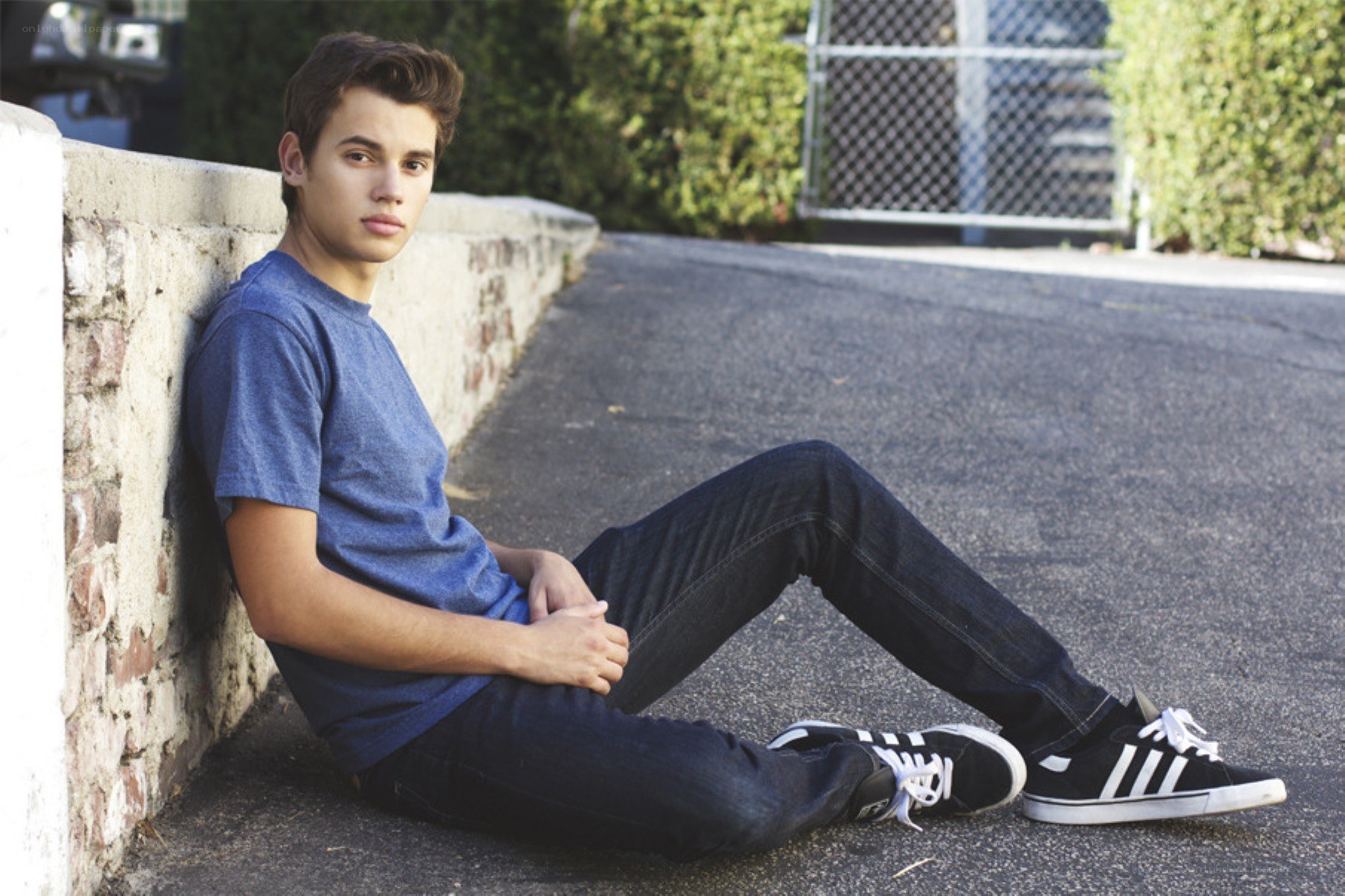 young man sitting on pavement
