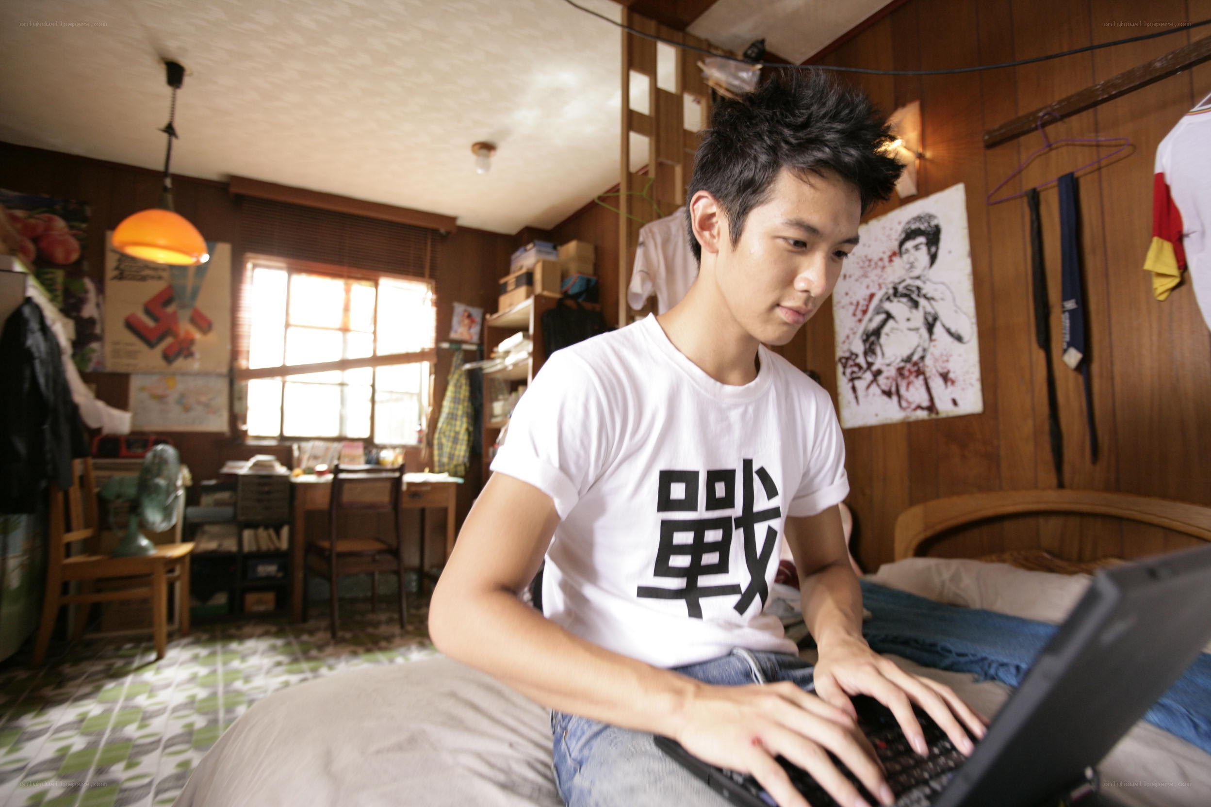 Young man using laptop in bedroom