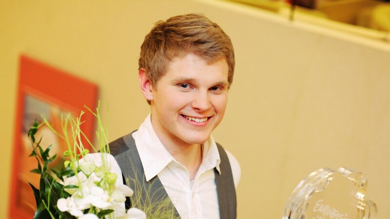 Young man with flowers and trophy
