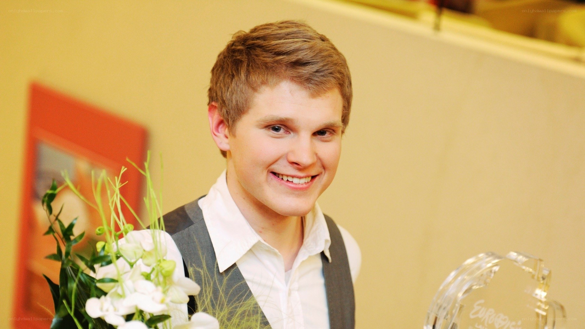 Young man with flowers and trophy