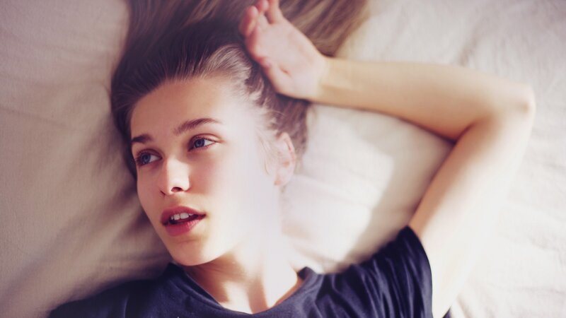 Young Woman Lying on Bed — White, Calm