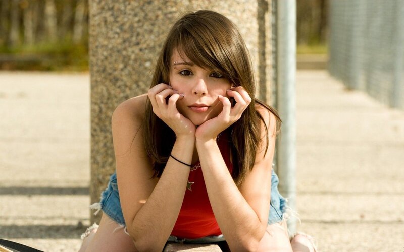 Young Woman Sitting Outside — Brown