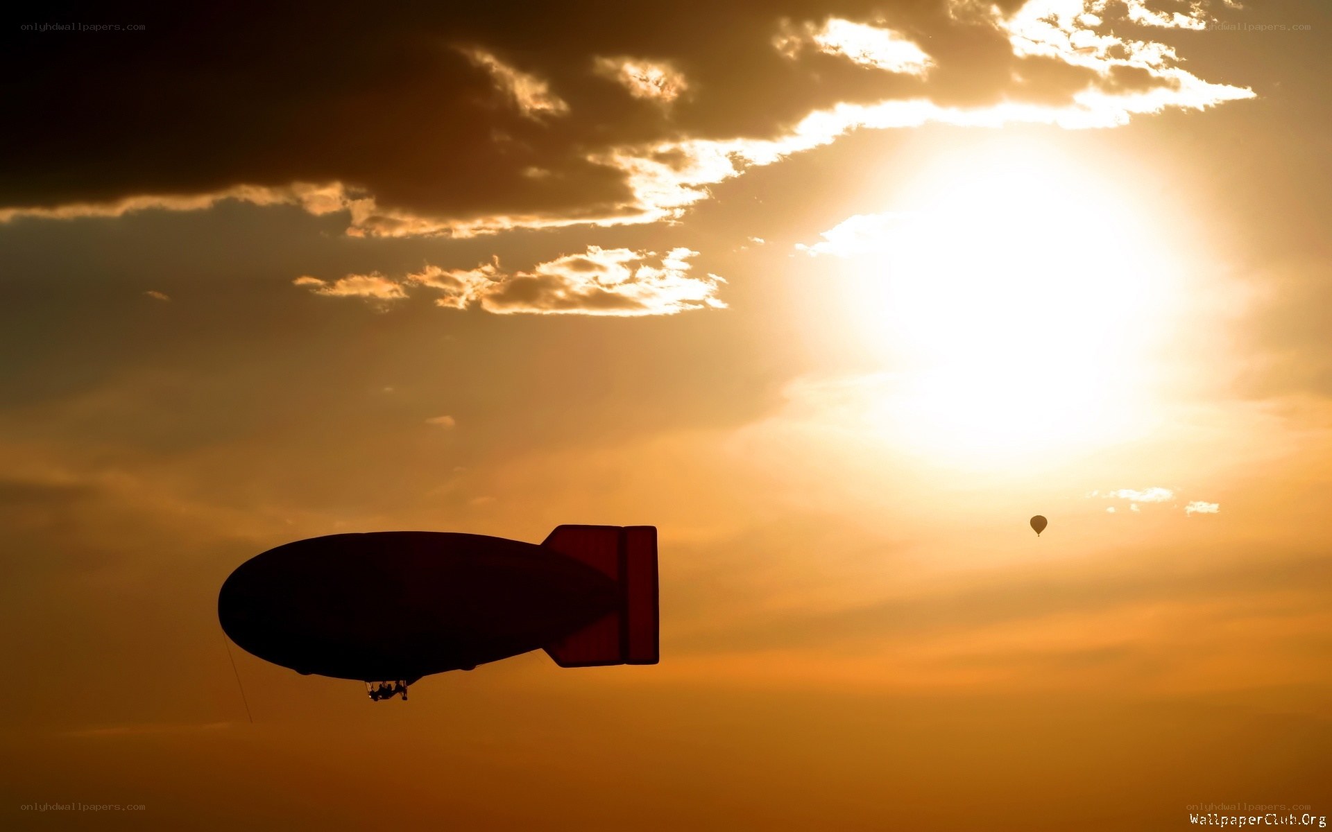 Zeppelin at sunset with hot air balloon